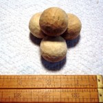 a neat pile of 4 3/4 inch wooden balls