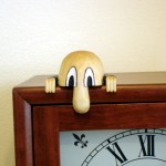 photo of kilroy carving sitting on a mantle clock