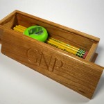 photo of a pencil box made of cherry with the initials G N P carved in the lid